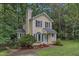 Beautiful two-story home with a lush green lawn and mature landscaping in wooded location at 4009 Olde Coach Rd, Durham, NC 27707