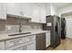 Updated kitchen featuring white cabinets, stainless steel appliances, and quartz countertops at 4645 Edwards Mill Rd, Raleigh, NC 27612