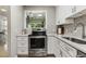 Updated kitchen with stainless steel appliances, white cabinets, and modern gray backsplash at 4645 Edwards Mill Rd, Raleigh, NC 27612