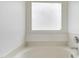 Clean, minimalist bathtub with a frosted window for privacy and soft lighting at 4905 Knightsbridge Way, Raleigh, NC 27604