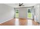 Bright bedroom featuring wood floors, a ceiling fan, and two windows with views of the outdoors at 4905 Knightsbridge Way, Raleigh, NC 27604