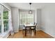 Bright dining room with beautiful hardwood floors, a modern light fixture and natural light at 4905 Knightsbridge Way, Raleigh, NC 27604