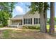 Inviting home with a cozy front porch, complemented by lush greenery and mature trees at 4905 Knightsbridge Way, Raleigh, NC 27604