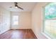 Bedroom with a ceiling fan, wood floors and large window at 507 N Elm St, Durham, NC 27701