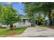 Charming green home featuring a cozy front porch with white railing and a well-manicured lawn at 507 N Elm St, Durham, NC 27701