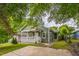 Inviting green home with a white porch and railing, surrounded by lush greenery and a driveway at 507 N Elm St, Durham, NC 27701