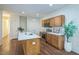 Well-lit kitchen with wood cabinets, stainless appliances, a large island, and white countertops at 507 N Elm St, Durham, NC 27701