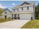 Charming two-story home with light gray siding, stone accents and a two-car garage at 516 Winding Creek Dr, Lillington, NC 27546
