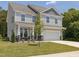 Charming two-story home with light gray siding, stone accents and a two-car garage at 516 Winding Creek Dr, Lillington, NC 27546