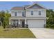 Charming two-story home with light gray siding, stone accents and a two-car garage at 516 Winding Creek Dr, Lillington, NC 27546