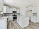 Modern kitchen with white cabinets, stainless steel appliances, and a functional island at 516 Winding Creek Dr, Lillington, NC 27546