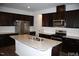 Modern kitchen featuring stainless steel appliances, granite countertops, and dark wood cabinets at 526 Catalina Grande Dr, Cary, NC 27519