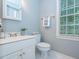 Well-lit bathroom features a white vanity and sink, with a window view of nature at 5401 Fire Pink Way, Raleigh, NC 27613
