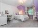 Bright bedroom featuring purple accent wall, large window, and chandelier at 5401 Fire Pink Way, Raleigh, NC 27613