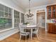Bright dining area featuring hardwood floors, chandelier and a round table next to large windows at 5401 Fire Pink Way, Raleigh, NC 27613