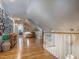 Upstairs hallway featuring hardwood floors, sloped ceilings, and decorative gallery wall at 5401 Fire Pink Way, Raleigh, NC 27613