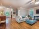 Open living room featuring hardwood floors, a comfy sofa, stylish ottoman, and a ceiling fan at 5401 Fire Pink Way, Raleigh, NC 27613