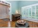 Sitting room showing a charming piano, shuttered windows, and view into foyer with beautiful hardwood floors at 5401 Fire Pink Way, Raleigh, NC 27613