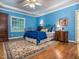 Spacious bedroom boasts an ornate bed, wooden floors, ceiling fan, tray ceiling, and natural light at 5401 Fire Pink Way, Raleigh, NC 27613