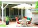 Charming covered patio with brick floor, outdoor seating, table, umbrella, and decorative plants at 5401 Fire Pink Way, Raleigh, NC 27613