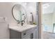 Bathroom featuring a gray vanity with a round mirror, sleek fixtures, and access to the staircase at 6 Beaver Creek Lane Ln, Durham, NC 27703