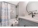 Bathroom with a shower/tub combo with sleek tile, large mirror, and blue-gray vanity at 6 Beaver Creek Lane Ln, Durham, NC 27703
