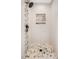 Modern shower featuring decorative tiles, a rainfall shower head, a built-in niche, and decorative hexagonal floor tiles at 6 Beaver Creek Lane Ln, Durham, NC 27703