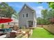 Backyard of a gray two-story home featuring a patio with fire pit, grill, and green lawn at 647 N Hardee St, Durham, NC 27703