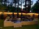 This backyard offers an inviting patio with a firepit and fence strung with decorative lights for nighttime enjoyment at 647 N Hardee St, Durham, NC 27703