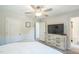 Bright bedroom with ceiling fan, closet, and dresser leading to the bathroom at 647 N Hardee St, Durham, NC 27703