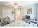 Cozy bedroom featuring neutral tones, ceiling fan, TV, and adjacent closet at 647 N Hardee St, Durham, NC 27703