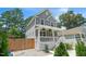Gray two-story home with white trim, featuring a covered porch and landscaped yard with wooden fence at 647 N Hardee St, Durham, NC 27703