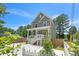 Two-story home with white-railed porch, concrete drive, and mature trees in a fenced yard at 647 N Hardee St, Durham, NC 27703