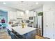 Bright kitchen with stainless appliances, white cabinetry, subway tile backsplash, and center island at 647 N Hardee St, Durham, NC 27703