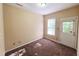 Bedroom with carpet flooring, a double-hung window, and a door leading to the exterior of the home at 650 Ganyard Farm Way # 41, Durham, NC 27703