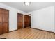 Clean bedroom with wood-look flooring and neutral walls features a closet and interior door at 6516 Hearthstone Dr # 6516, Raleigh, NC 27615