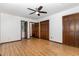 A bedroom featuring laminate flooring, a ceiling fan, and several closets at 6516 Hearthstone Dr # 6516, Raleigh, NC 27615