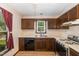 A full kitchen featuring wooden cabinets, laminate countertops, and a double basin sink at 6516 Hearthstone Dr # 6516, Raleigh, NC 27615