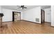 An empty living room featuring a brick fireplace, laminate flooring, and a ceiling fan at 6516 Hearthstone Dr # 6516, Raleigh, NC 27615