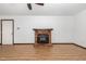 Open living room features a cozy brick fireplace, ceiling fan, and attractive wood-look floors at 6516 Hearthstone Dr # 6516, Raleigh, NC 27615