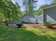View of the backyard that includes an outdoor fire pit, with the home and additional building at 707 Lakewood Dr, Siler City, NC 27344