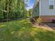 View of the backyard with mature trees and a black chain link fence at 707 Lakewood Dr, Siler City, NC 27344