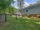 View of the backyard with a black chain link fence and a fire pit area at 707 Lakewood Dr, Siler City, NC 27344