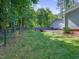 View of the backyard with a fire pit and a black chain link fence at 707 Lakewood Dr, Siler City, NC 27344