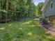 View of the backyard with mature trees and a black chain link fence at 707 Lakewood Dr, Siler City, NC 27344