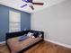 Stylish bedroom with wood floors, blue accent wall, and a ceiling fan at 707 Lakewood Dr, Siler City, NC 27344