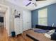 Bedroom featuring a blue accent wall, wood floors, and a dresser at 707 Lakewood Dr, Siler City, NC 27344