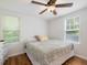 Cozy bedroom with hardwood floors, ceiling fan, and natural light from two windows at 707 Lakewood Dr, Siler City, NC 27344