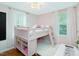 Pink bedroom with bunk bed, desk, and natural light from two windows at 707 Lakewood Dr, Siler City, NC 27344