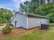 Side exterior view shows the light blue siding, landscaping, and AC unit at 707 Lakewood Dr, Siler City, NC 27344